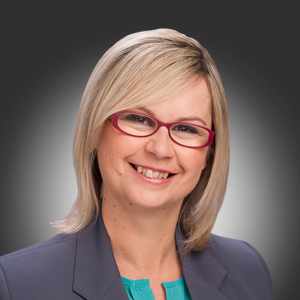 Image of Hon Clare Scriven with blonde hair and red glasses