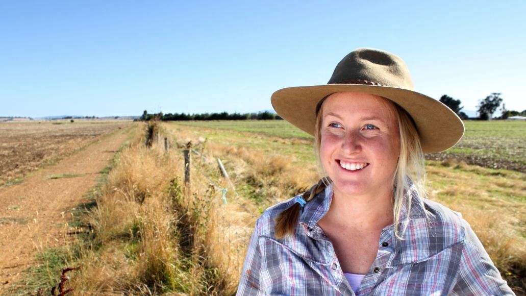 Smiling farmer overlooking dry field