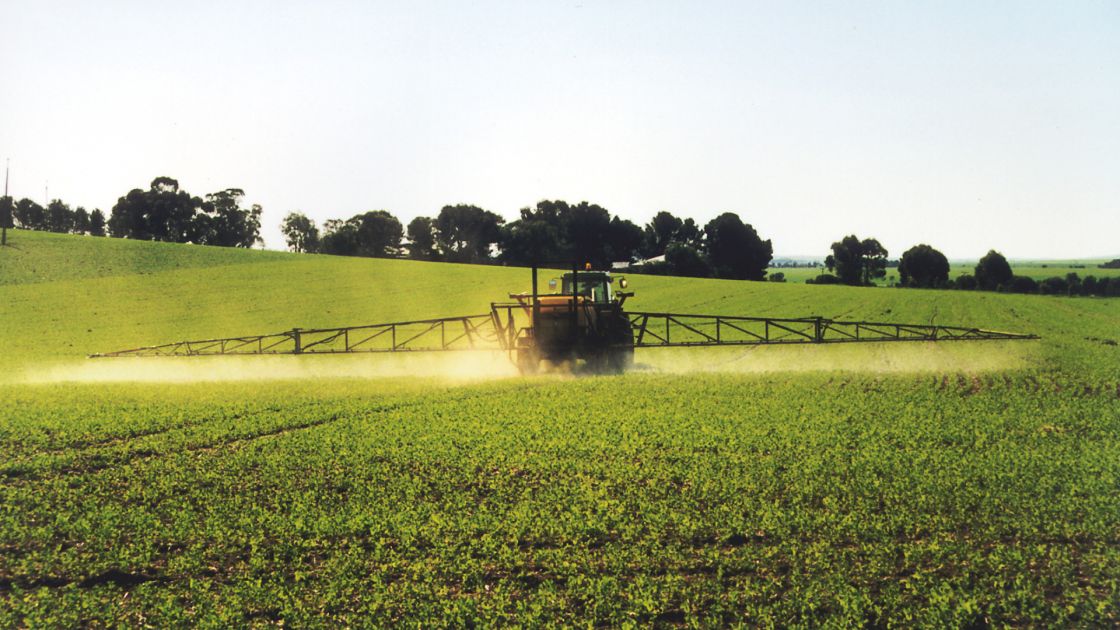 A tractor spraying herbicides on crops 