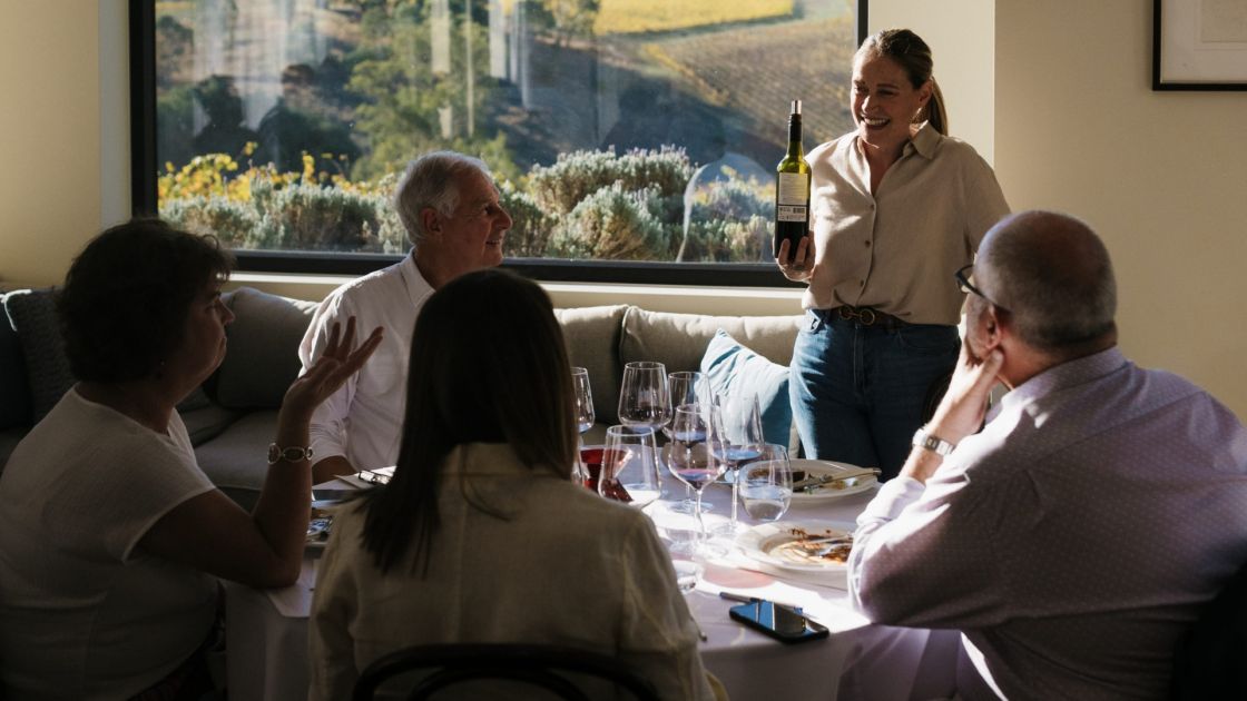 People enjoy wine around a table