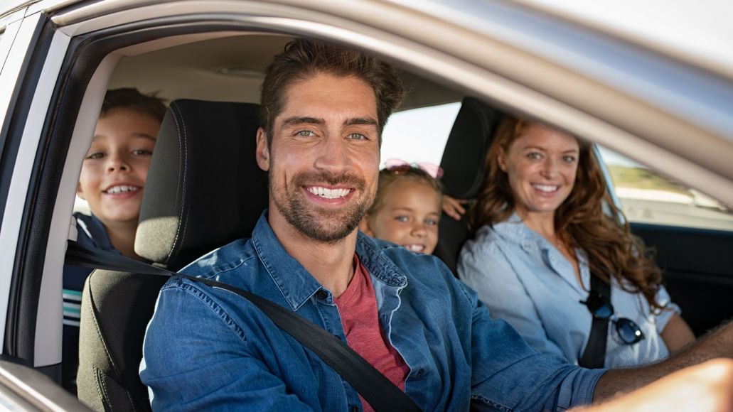 A man, woman and 2 children sitting in a car.