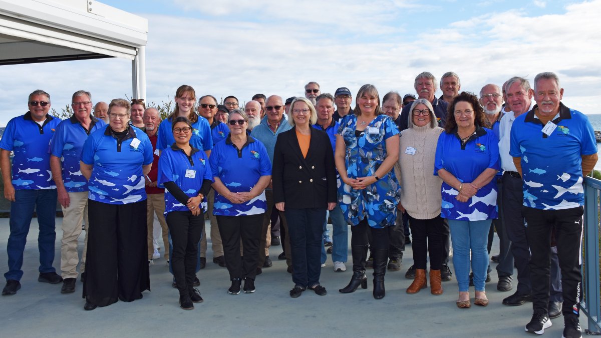 A group of Fishcare volunteers standing outside, with Minister Scriven standing at the front next to Fishcare Coordinator Toni Crosbie