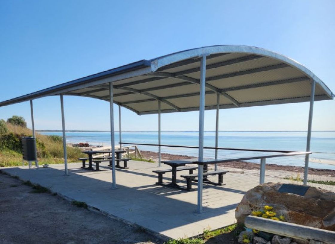 A shelter with tables and chairs overlooking the sea at Hardwicke Bay
