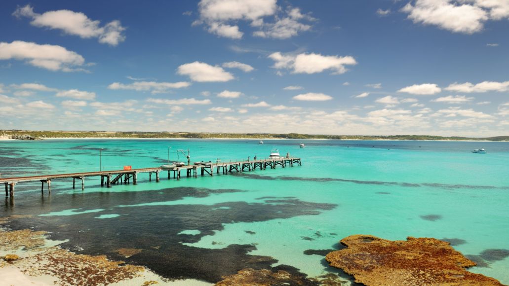 A clear blue bay with a jetty