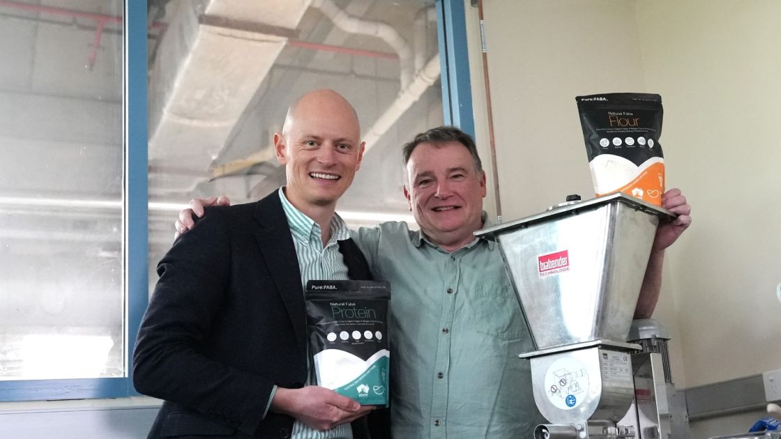 Integra Foods Chief Executive Officer Tom Reddecliffe holding a bag of protein powder standing next to SARDI's John Carragher in a food laboratory.