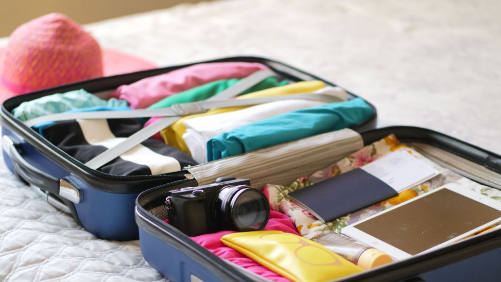 A packed suitcase, open on a bed.