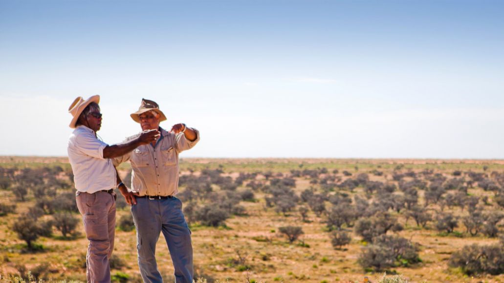 Two indigenous men looking over the desert