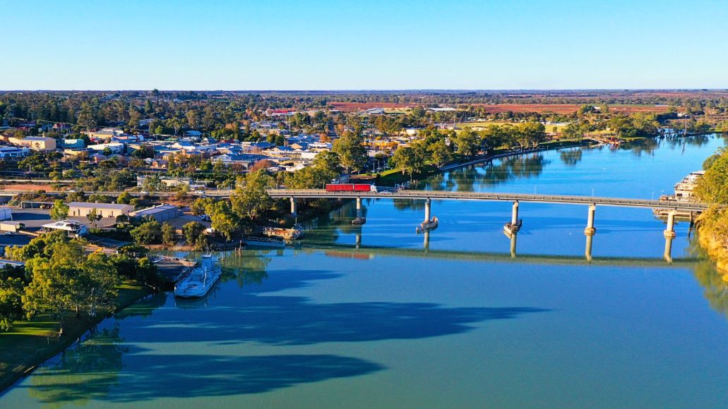 A road bridge stretching across the River Murray, with the town of Berri in the background.